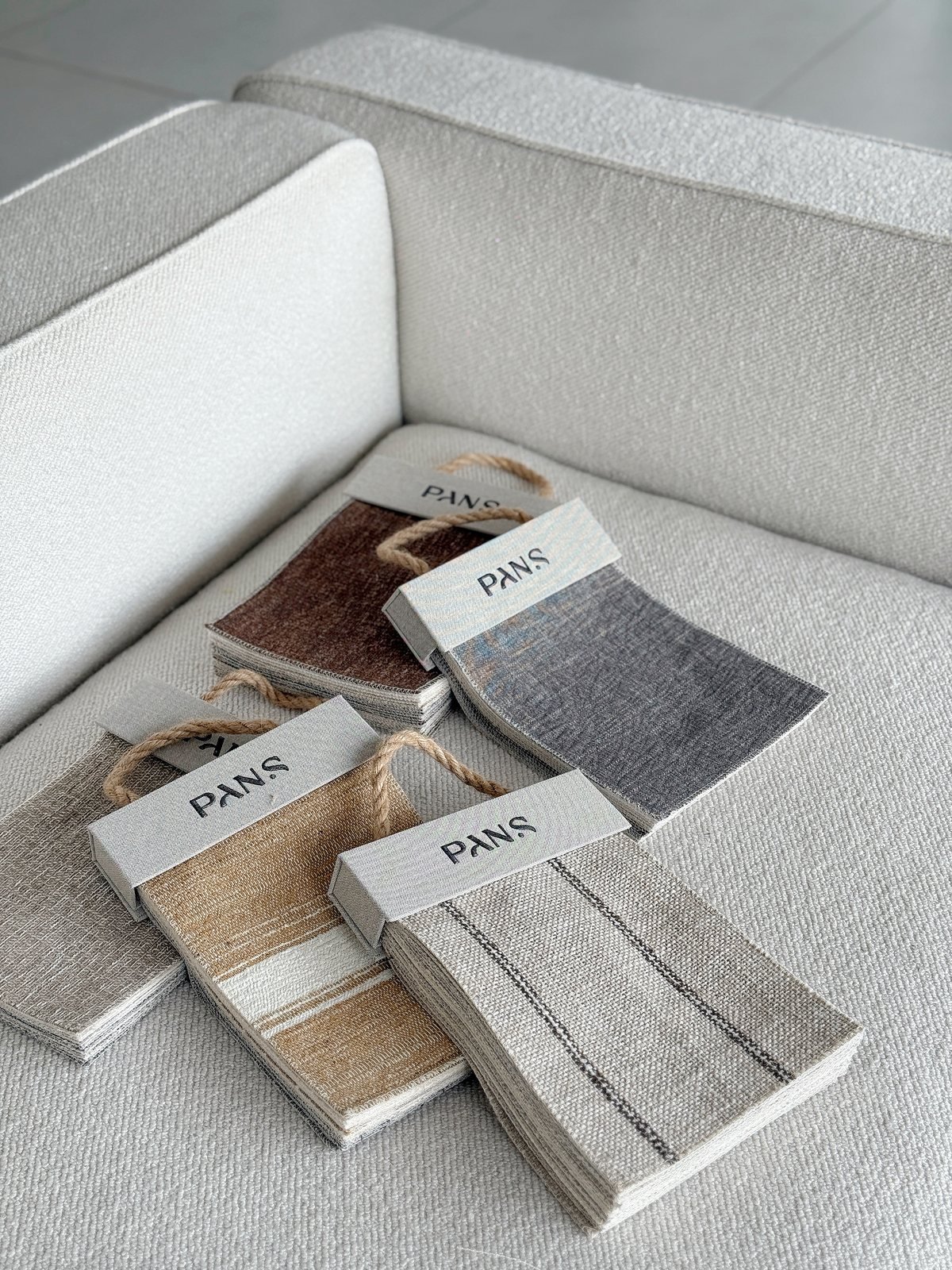Ksino fabric samples in warm neutral and grey tones